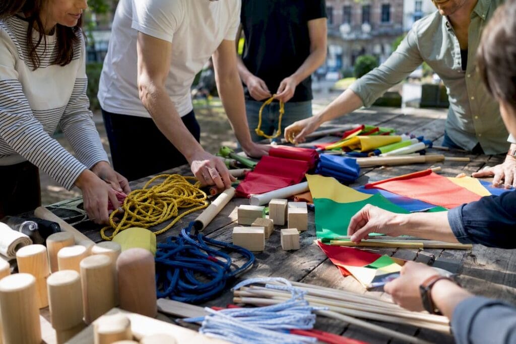 Des mains assemblant du matériel de team building en extérieur