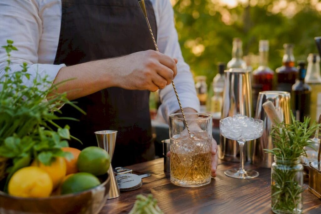 Les mains d'un mixologue en train de préparer un cocktail lors d'un atelier