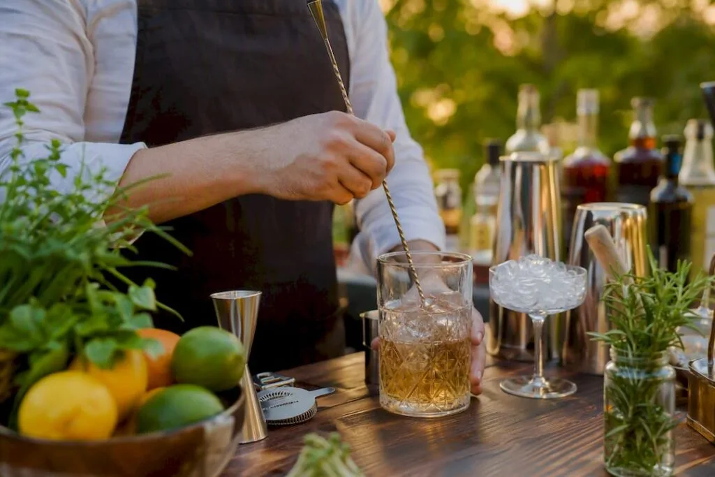 Les mains d'un mixologue en train de préparer un cocktail lors d'un atelier